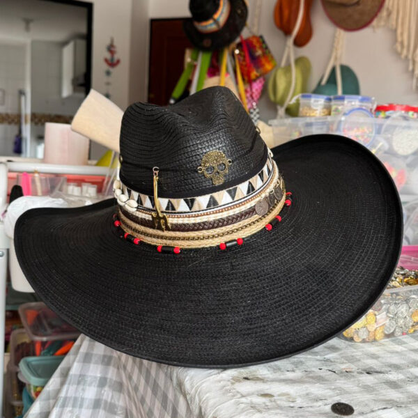 decorated hat, hats decorated in Colombia, personalized hats made from iraca palm, handmade hats with embroidery, test1234, Black Indiana hat decorated with golden skull, tribal bands, coins, and red accents – handcrafted rock-style for women