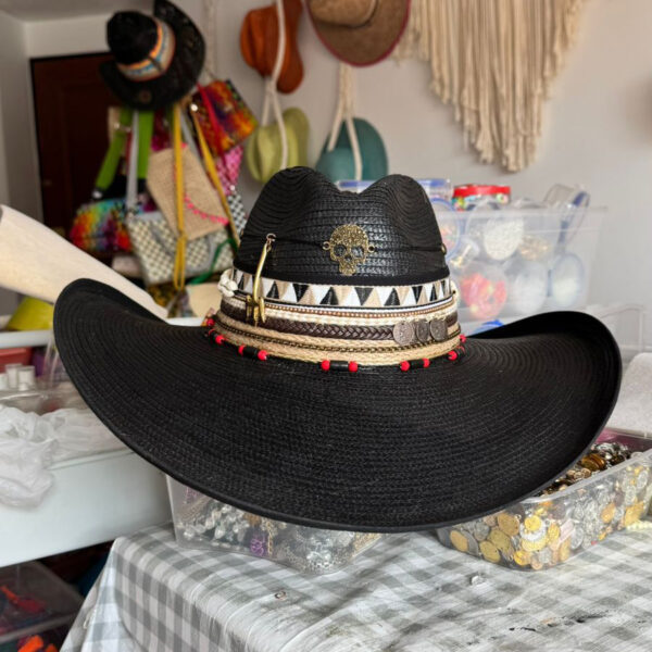 decorated hat, hats decorated in Colombia, personalized hats made from iraca palm, handmade hats with embroidery, test1234, Black Indiana hat decorated with golden skull, tribal bands, coins, and red accents – handcrafted rock-style for women