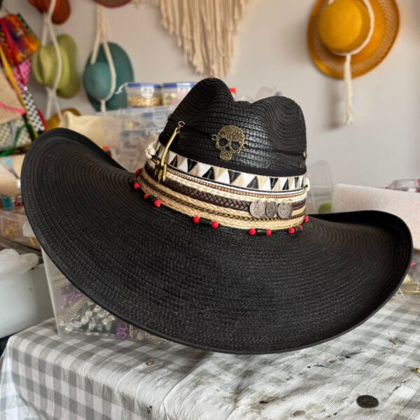 decorated hat, hats decorated in Colombia, personalized hats made from iraca palm, handmade hats with embroidery, test1234, Black Indiana hat decorated with golden skull, tribal bands, coins, and red accents – handcrafted rock-style for women